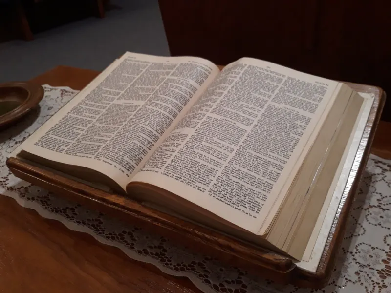 A well-worn Bible resting on a lace cloth